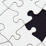 Imagen de un puzzle blanco con una ficha negra