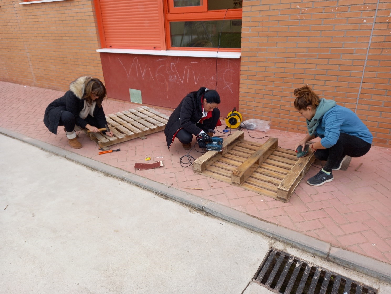 Las mamás (AMPA) y Estefanía (TIS) construyendo la pared musical.
