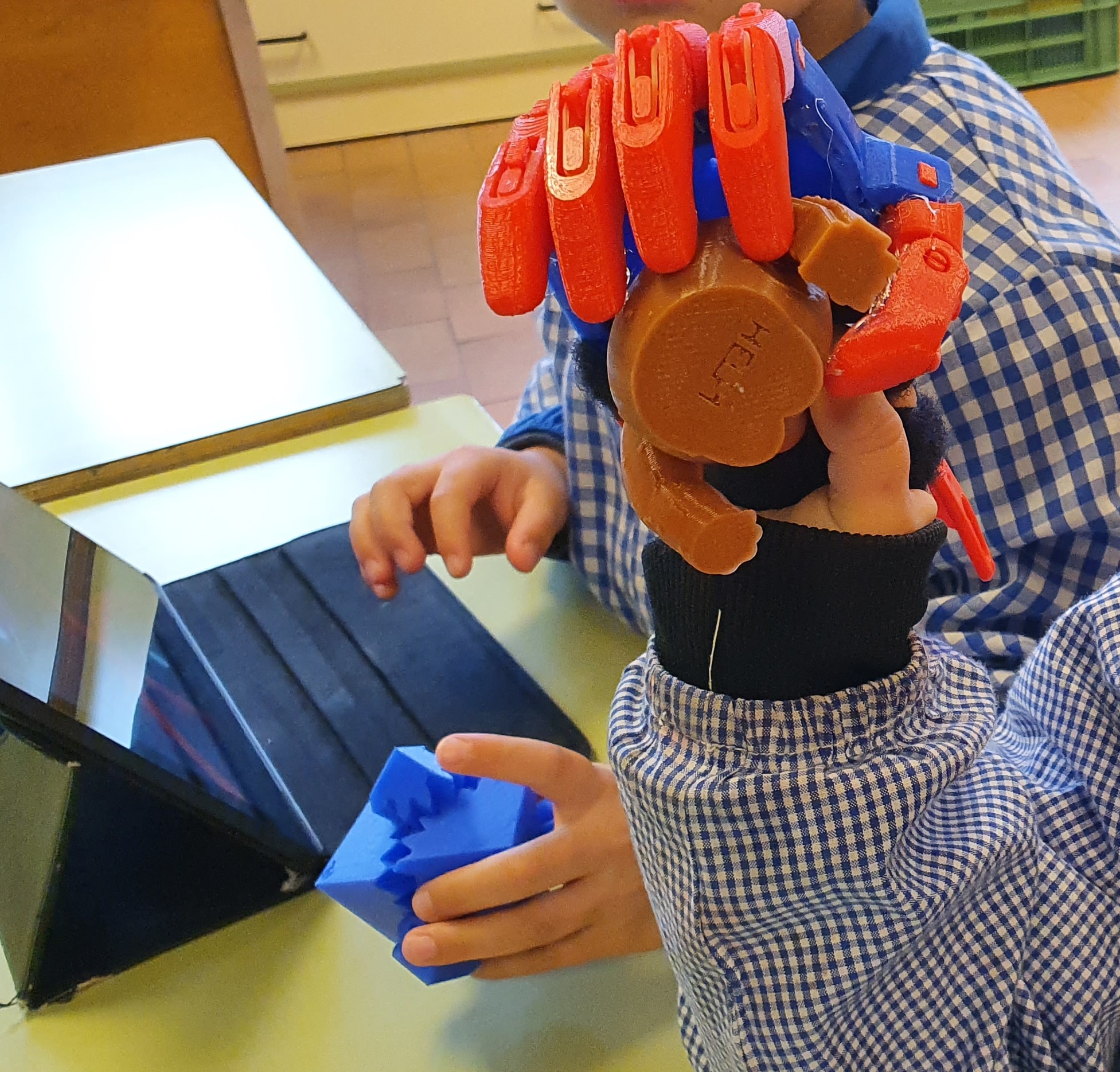  Alumnos de infantil probando manos protésicas construidas por el alumnado de 4º, 5º y 6º
