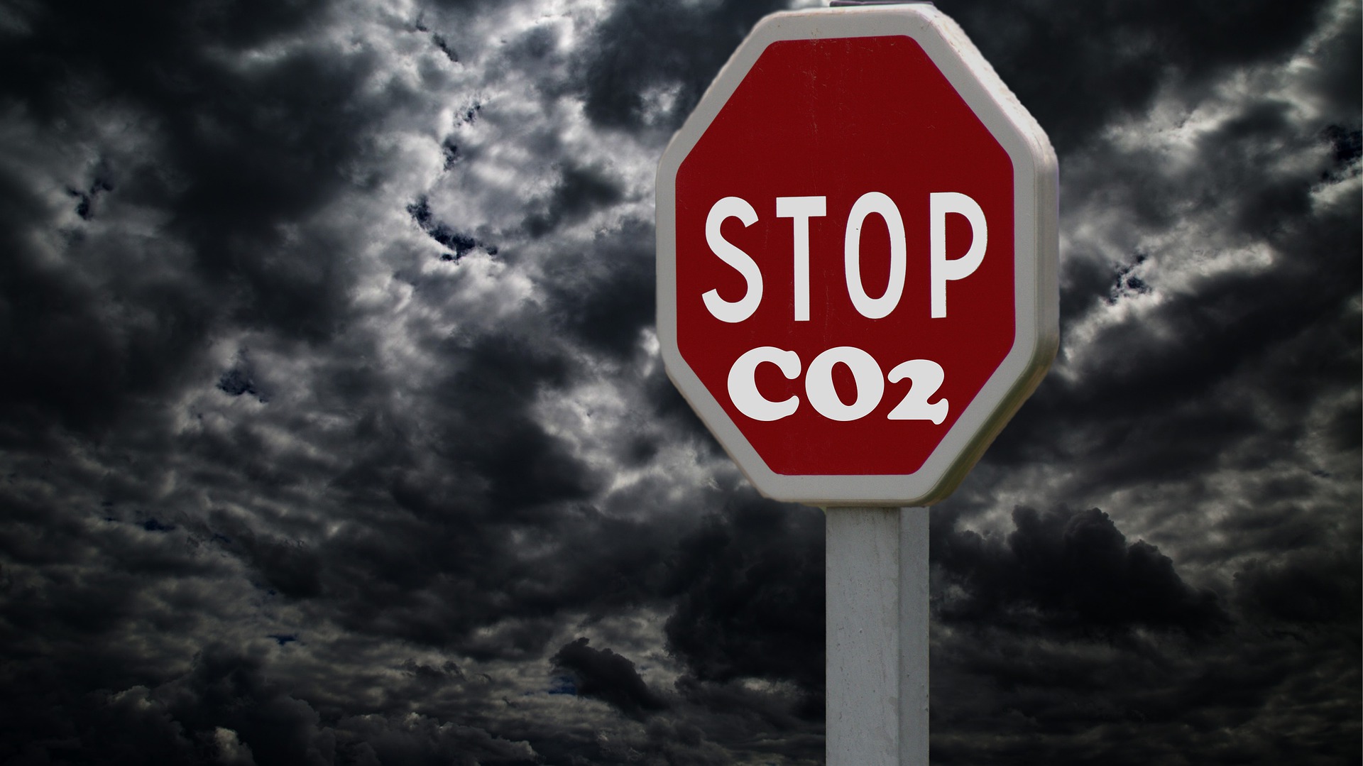 señal de stop con la palabra añadida C02 y fondo de nubes oscuras