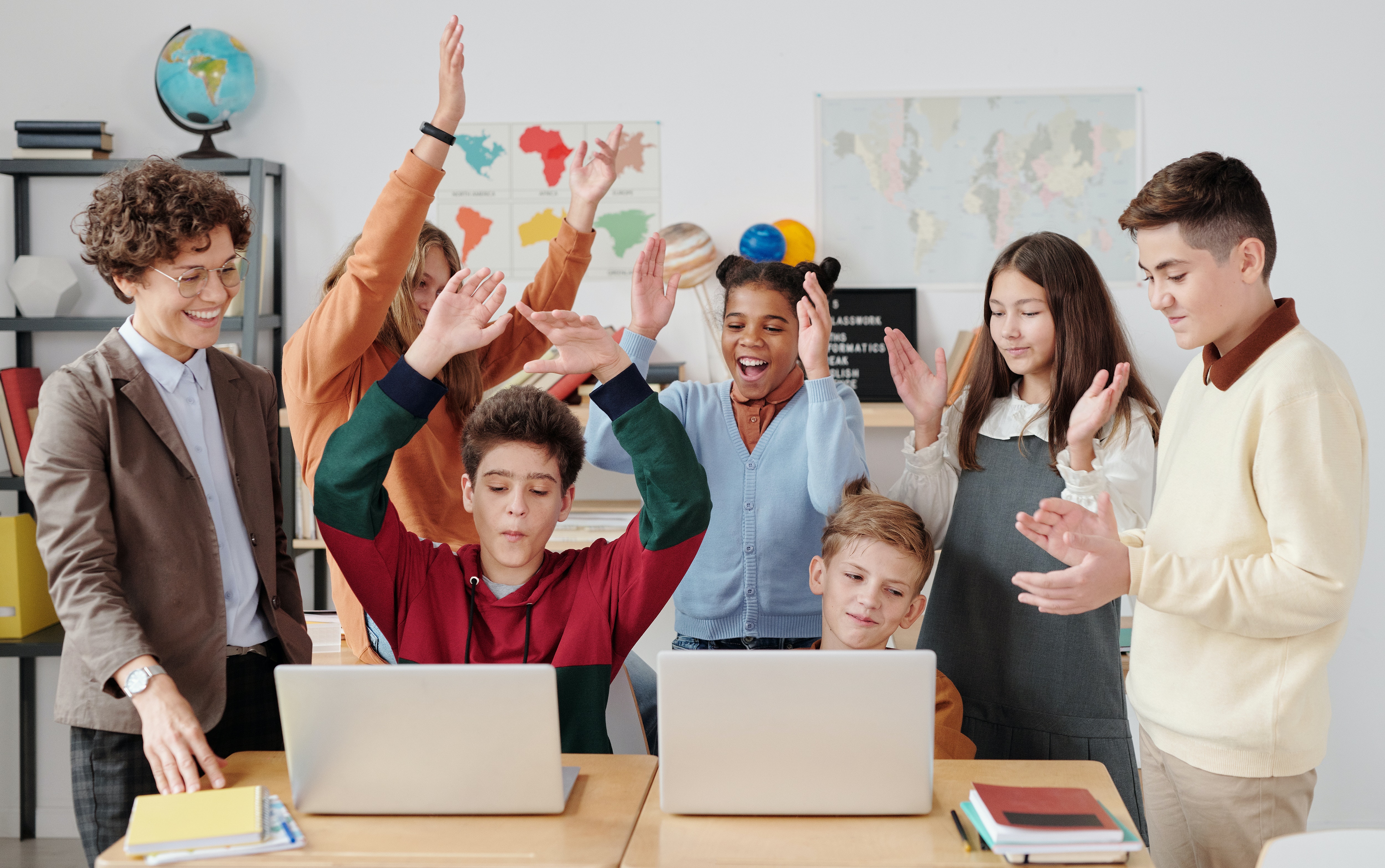 Grupo de clase celebra frente a portátiles